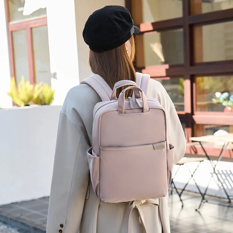 Large nylon women's travel backpack in apricot colour showing internal laptop compartment and multiple pockets.