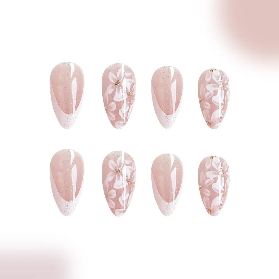 Short glossy almond-shaped press-on nails with French style, floral designs and glitter accents in C625 colour