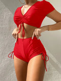 Women's dark green lace-up bow swimsuit top and shorts set for swimming.