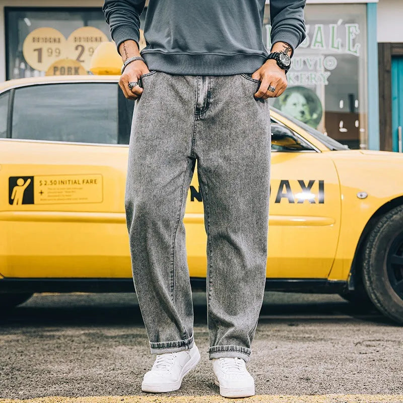 Men's loose straight-cut cotton jeans in dark blue, shown on a man in a casual setting.