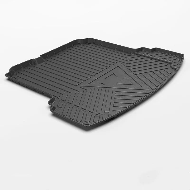 Black car boot liner with carbon fibre pattern texture, laid flat showing its tailored shape.