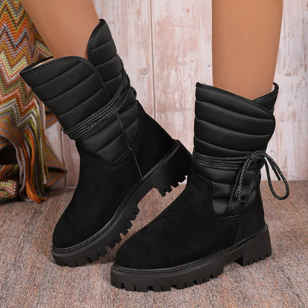 Women's chunky heel mid-calf snow boot with lace-up front and fleece lining in black, brown, or grey.