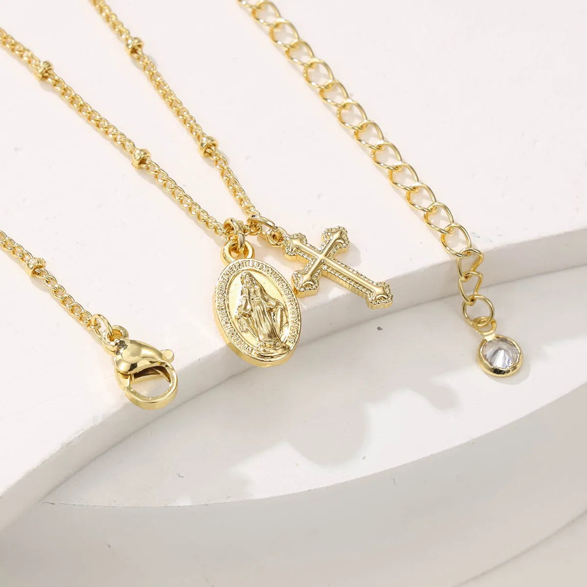 Gold Virgin Mary cross necklace with geometric design on chain