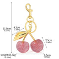 Three-dimensional cherry-shaped zinc alloy key ring pendant in pink or red colour.