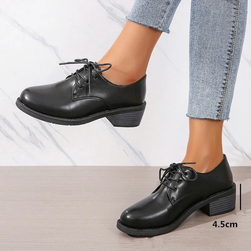Black women's low top work shoes with a short chunky heel and pointed toe.