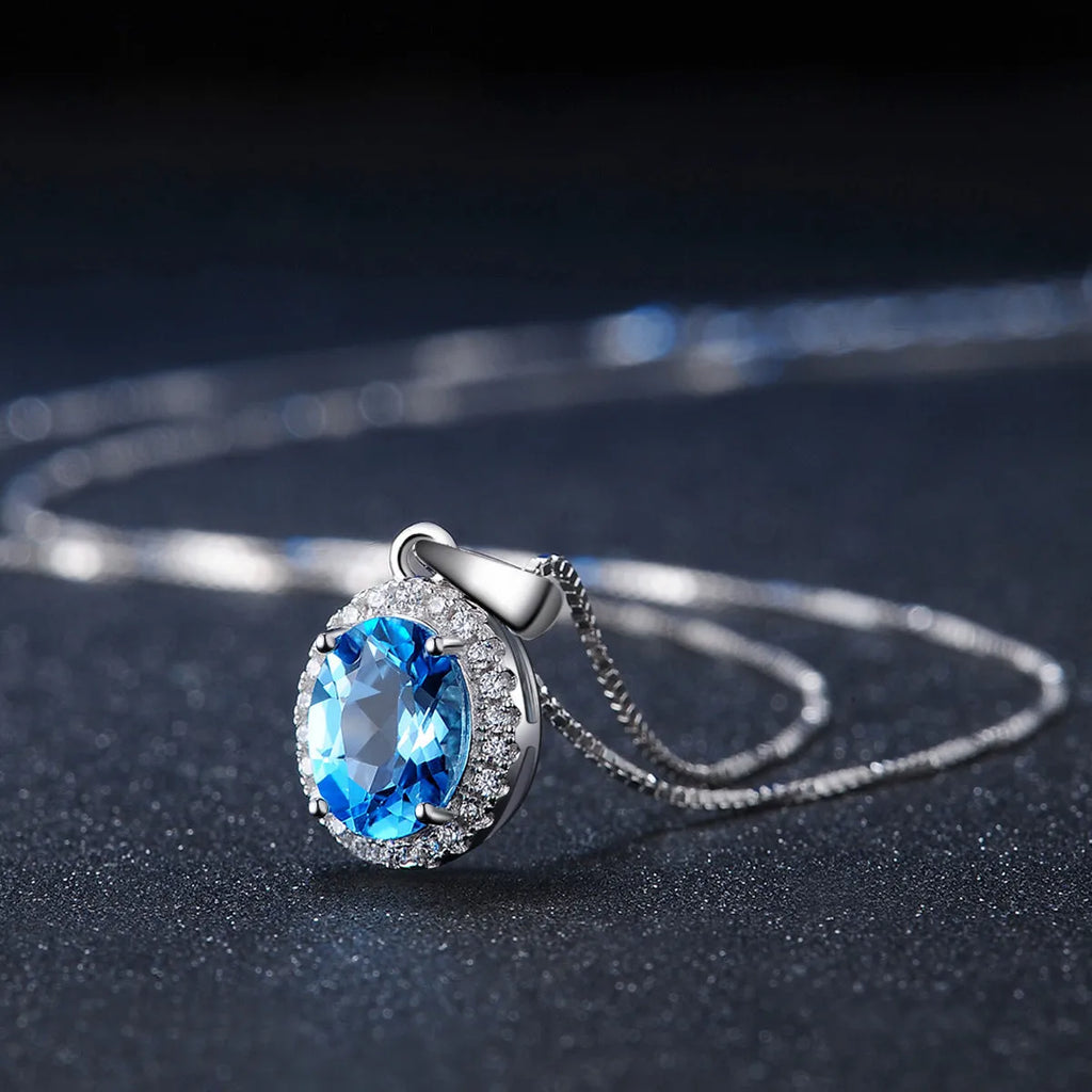 925 sterling silver jewellery set with blue topaz stones showing earrings, ring, pendant, and necklace with chain in geometric design