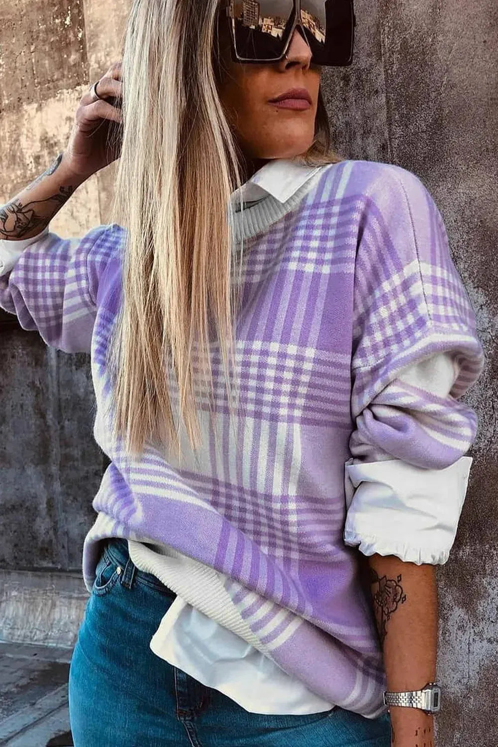 Loose lilac plaid print sweater with long sleeves and ribbed trim on a hanger.