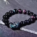 Natural ice colour Eye Obsidian crystal beaded bracelet on a wrist, showing clear spherical beads.