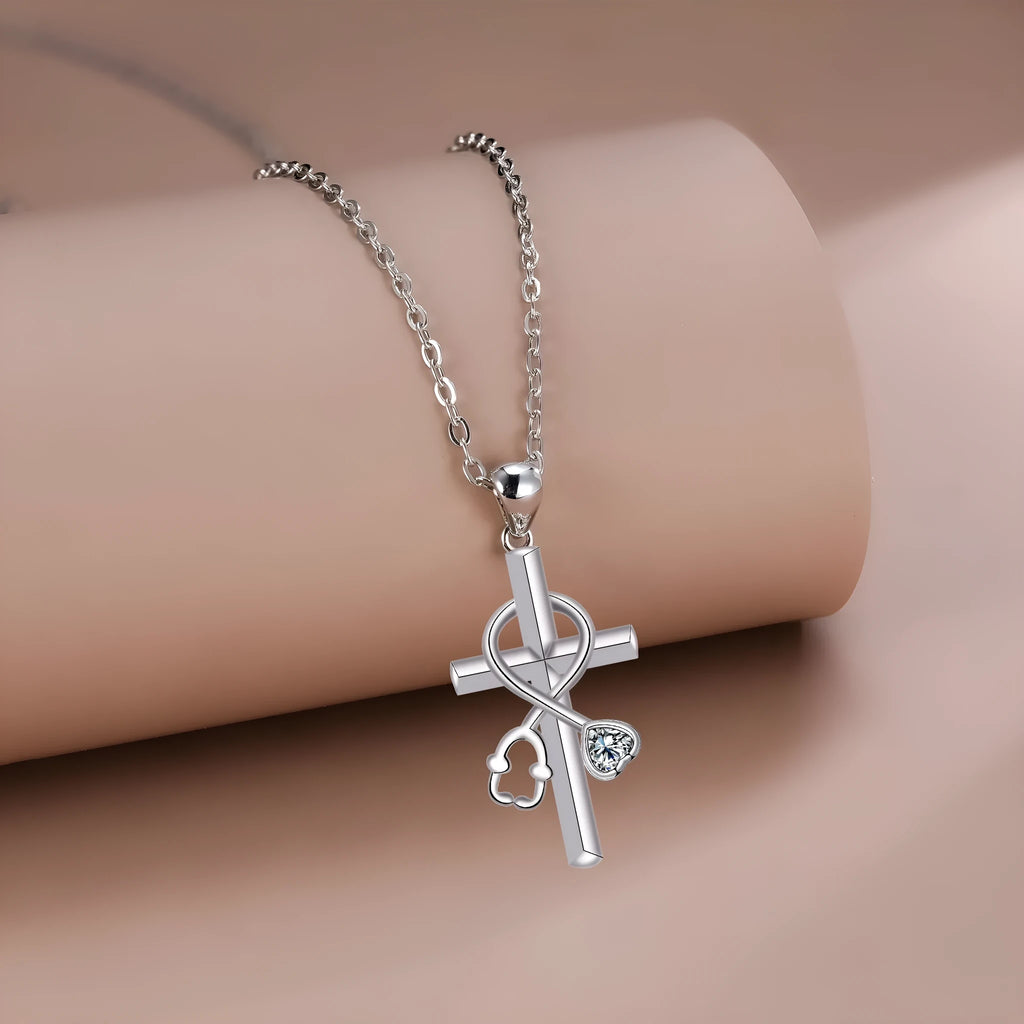 Silver-coloured women's necklace with a pendant shaped as a cross combined with a stethoscope.