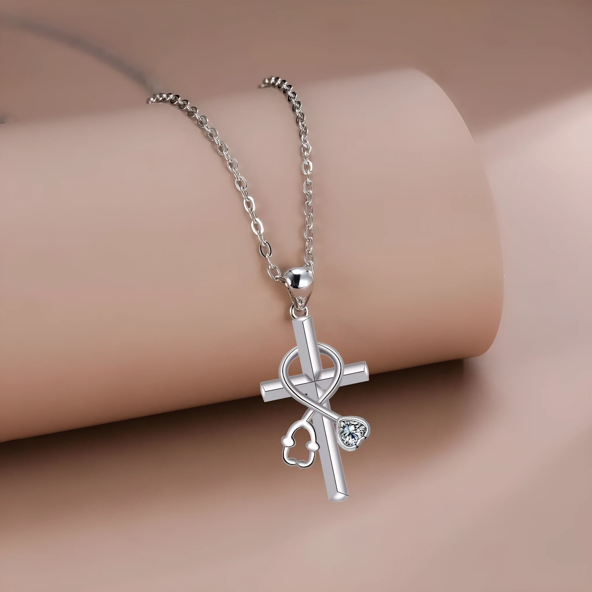 Silver-coloured women's necklace with a pendant shaped as a cross combined with a stethoscope.