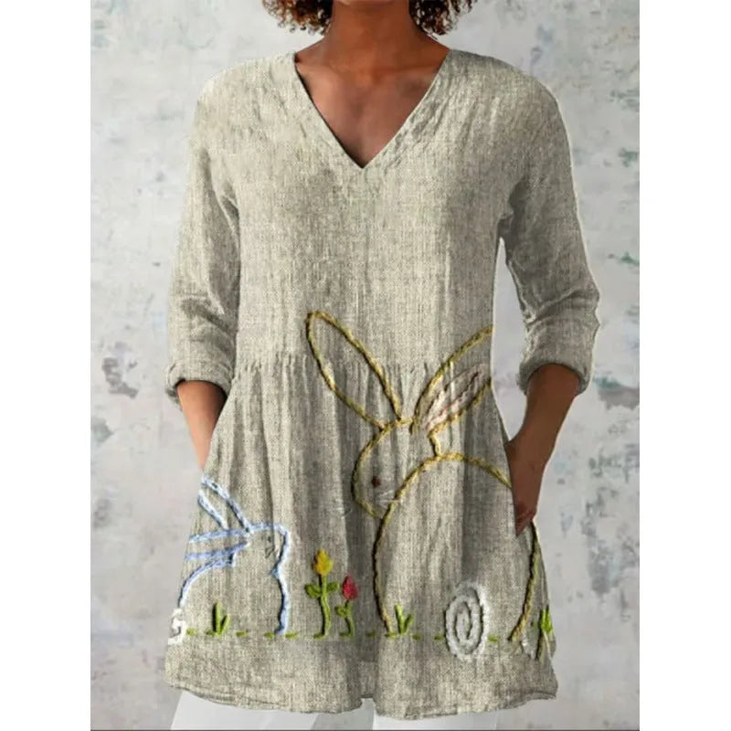 A woman wearing a loose, printed dress with 3/4 sleeves and a wide waist, available in multiple sizes.