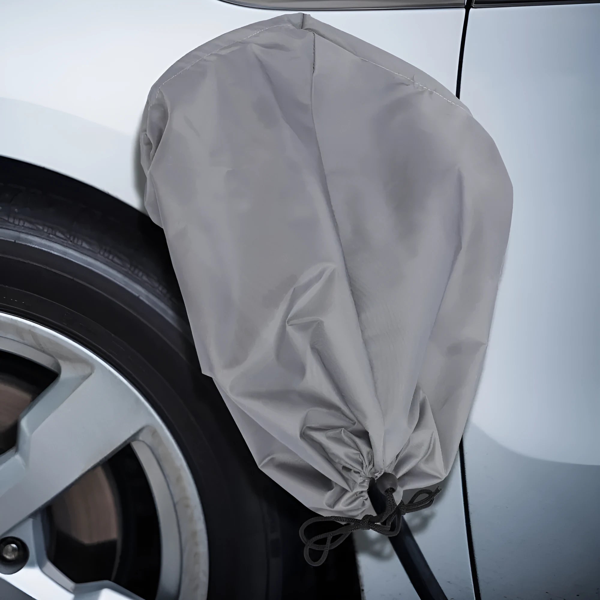Grey waterproof drawstring cover for electric vehicle charging port.