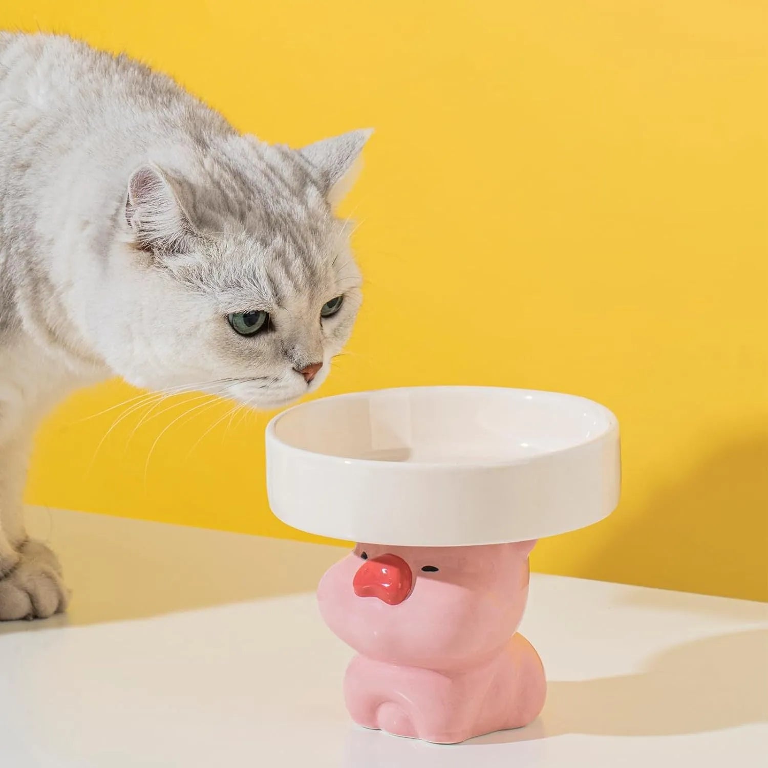 Ceramic elevated cat food bowl with animal theme design in pink, yellow, or white