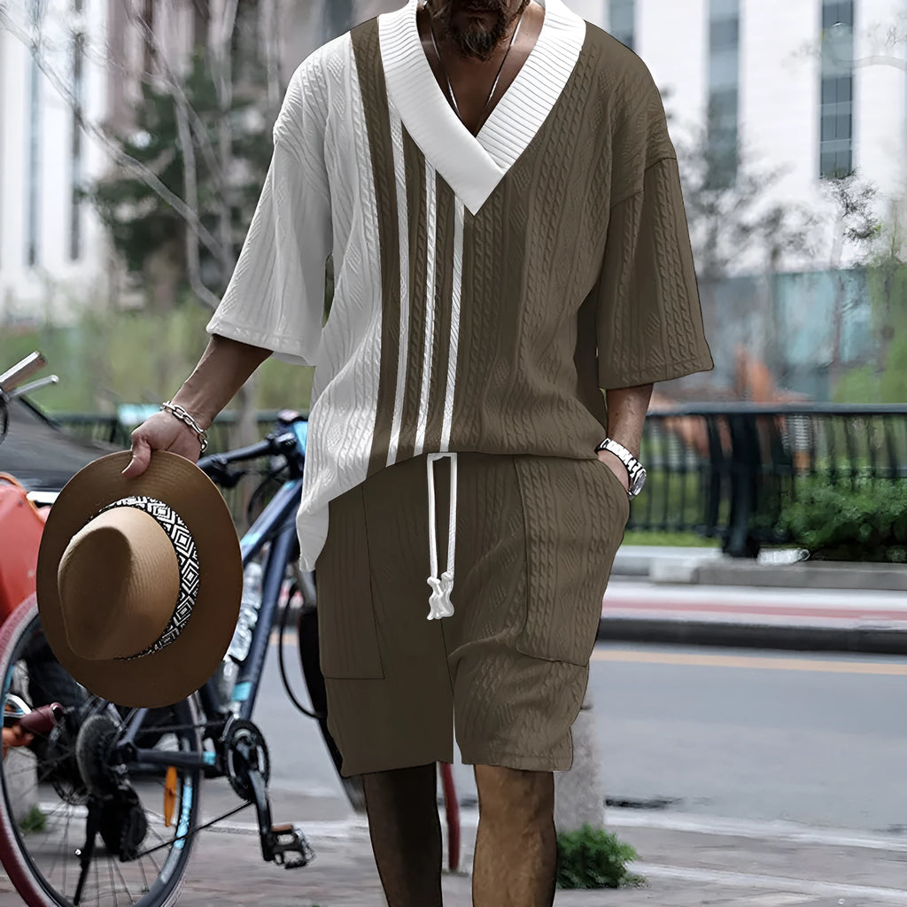 Man wearing a printed drop-shoulder knitted top and matching shorts from a two-piece lounge suit.