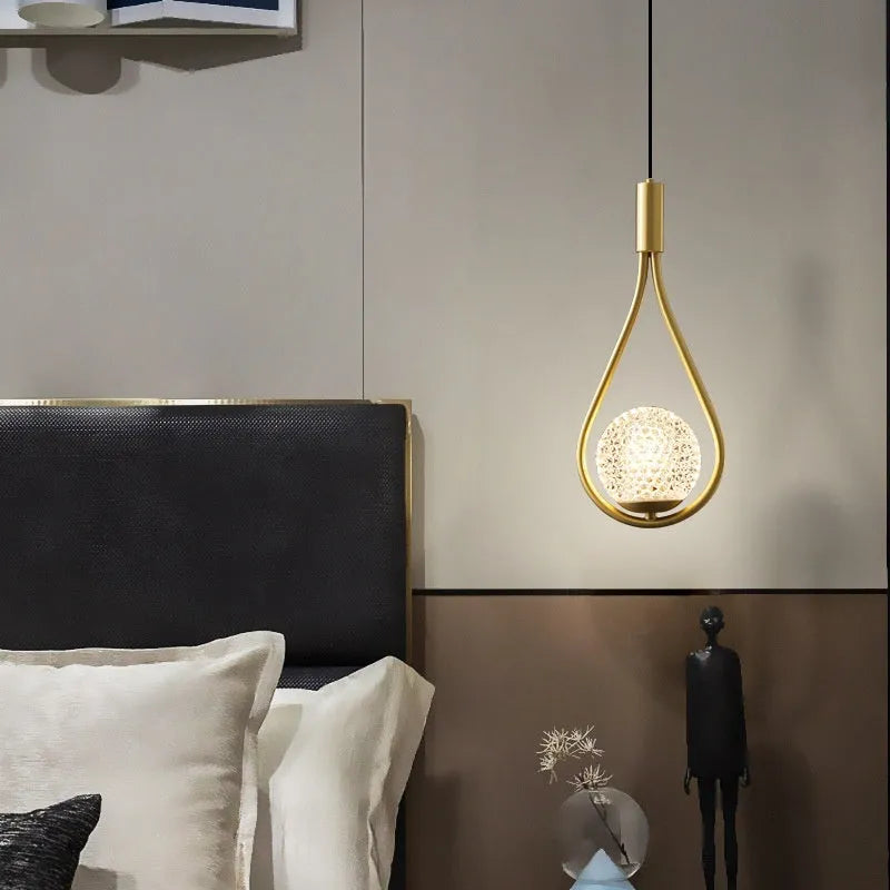 Modern copper bedside chandelier with adjustable hanging cord in minimalist bedroom setting