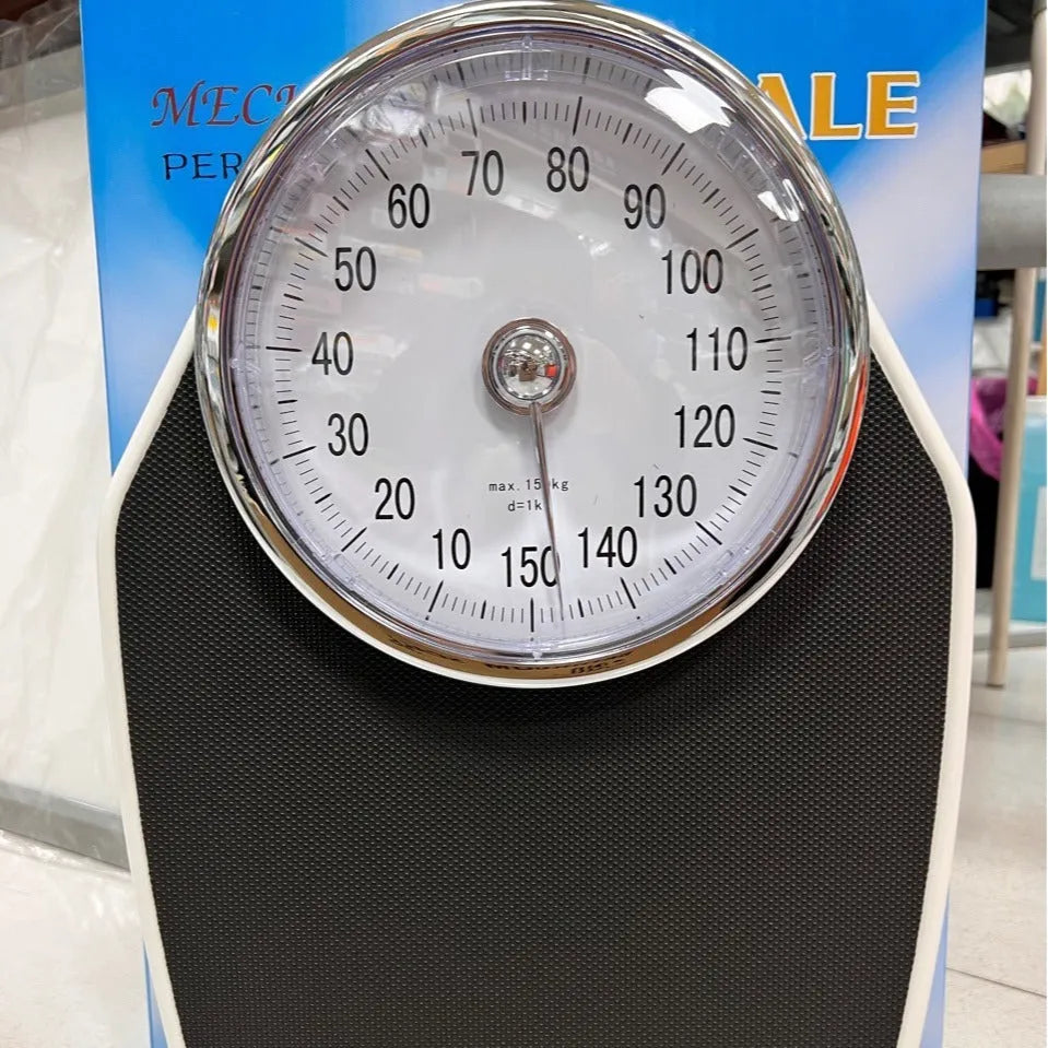 Black mechanical body weight scale with large dial showing weight measurements.