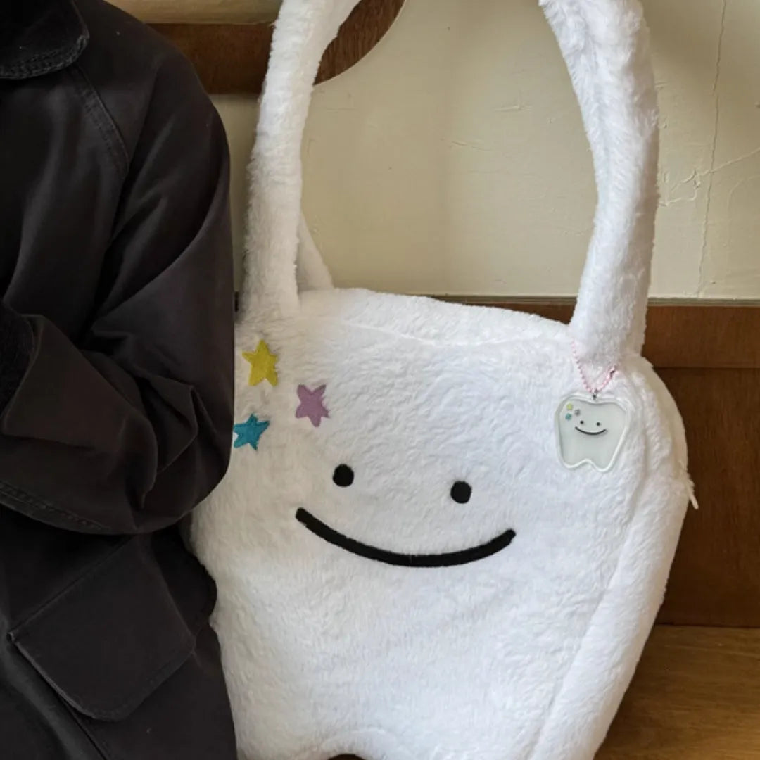 White plush tote bag with cute teeth pattern, showing crossbody strap and zipper closure.