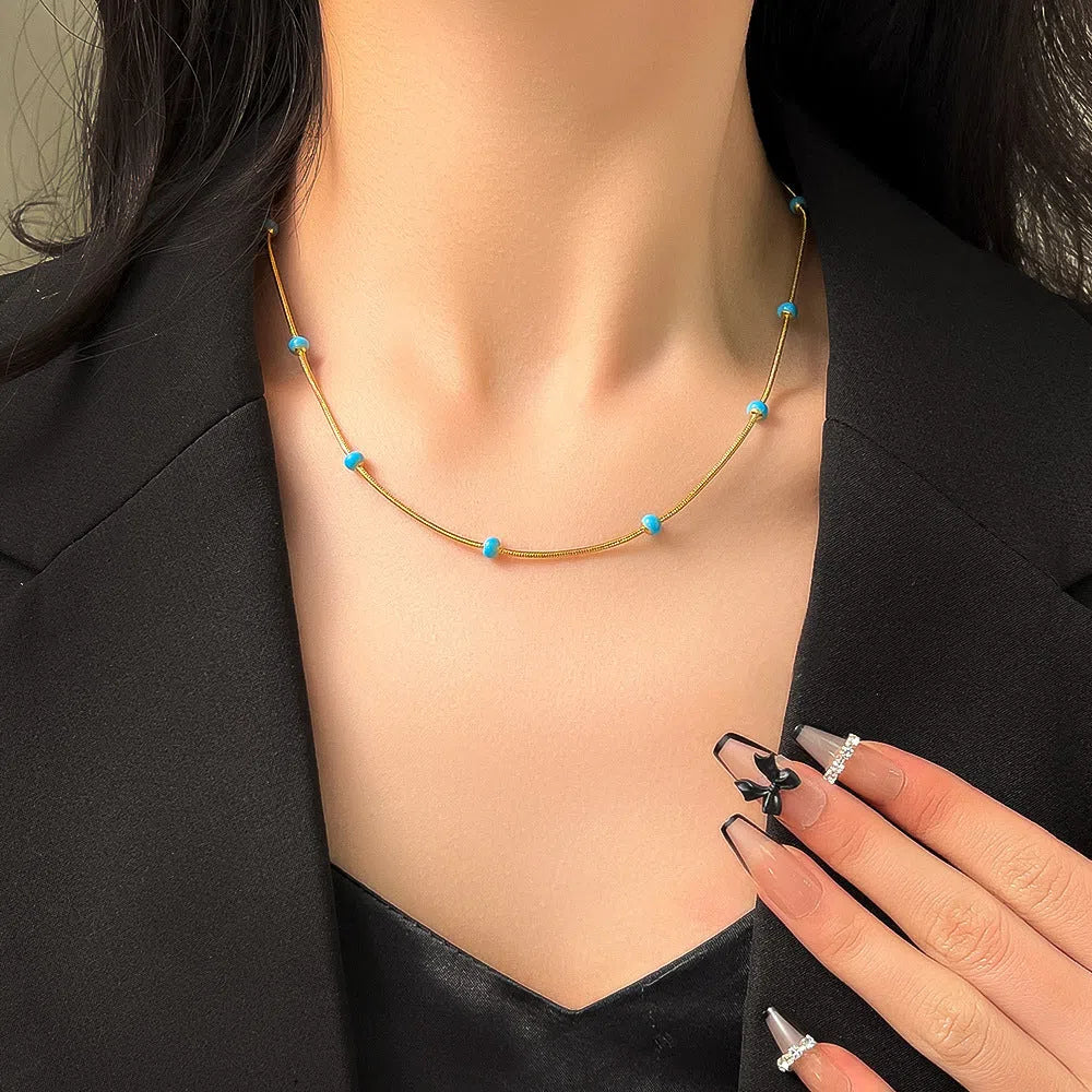 Titanium steel ball drop glaze necklace in green pearl gold, clavicle length, on model