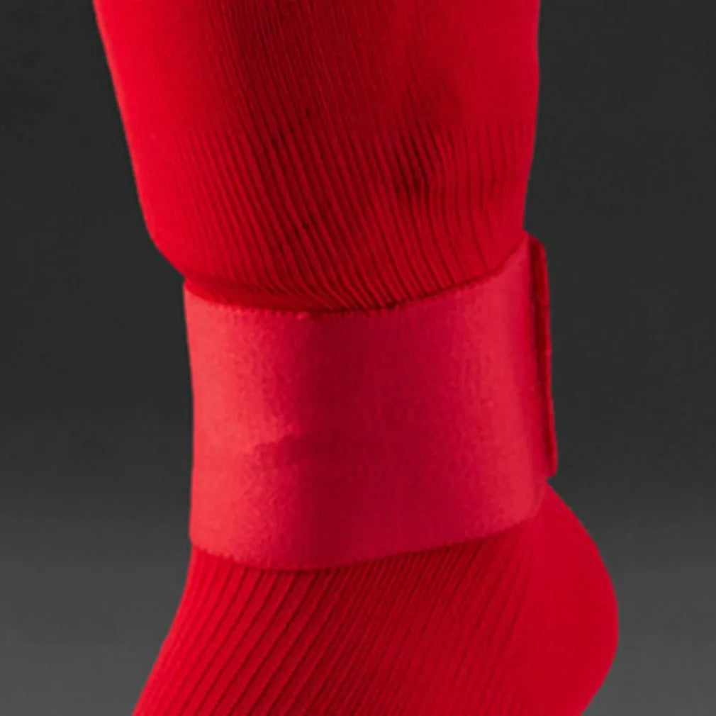 Rubber football shin guard belt in multiple colours securing protective pad on athlete's leg