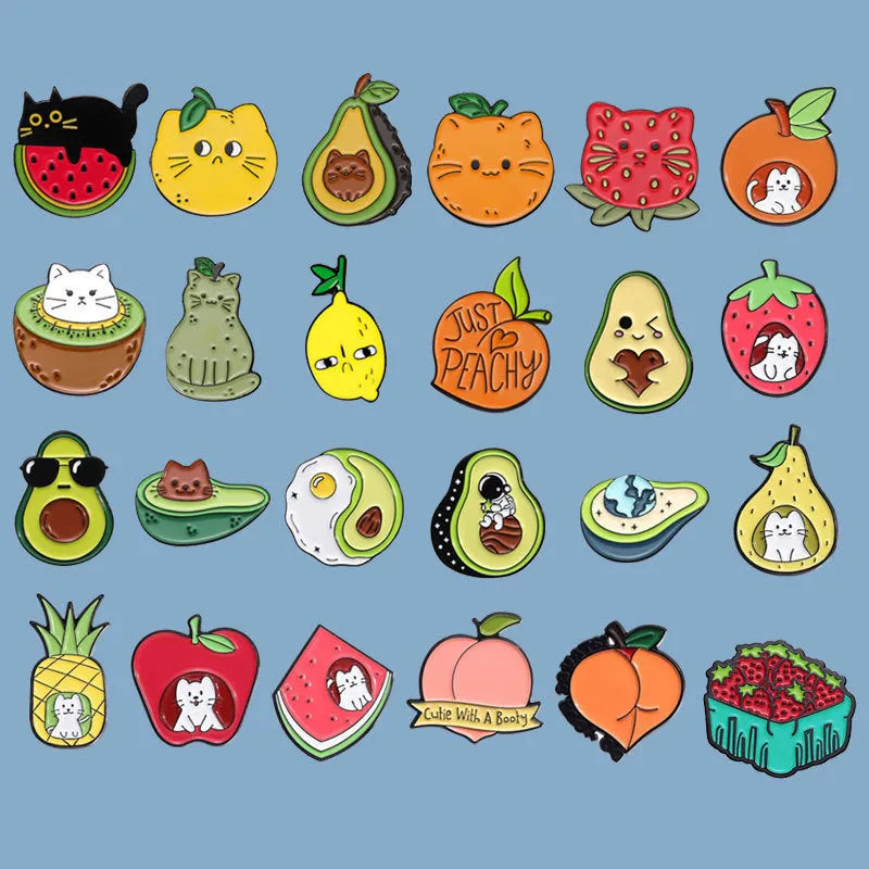 Colourful cartoon fruit design metal letter brooch on a fabric background.