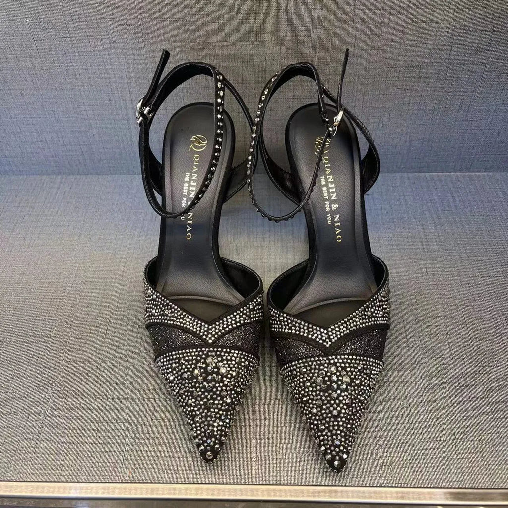 Women's black pointed toe high heels with a hollow stiletto heel and red sole, shown from the side.