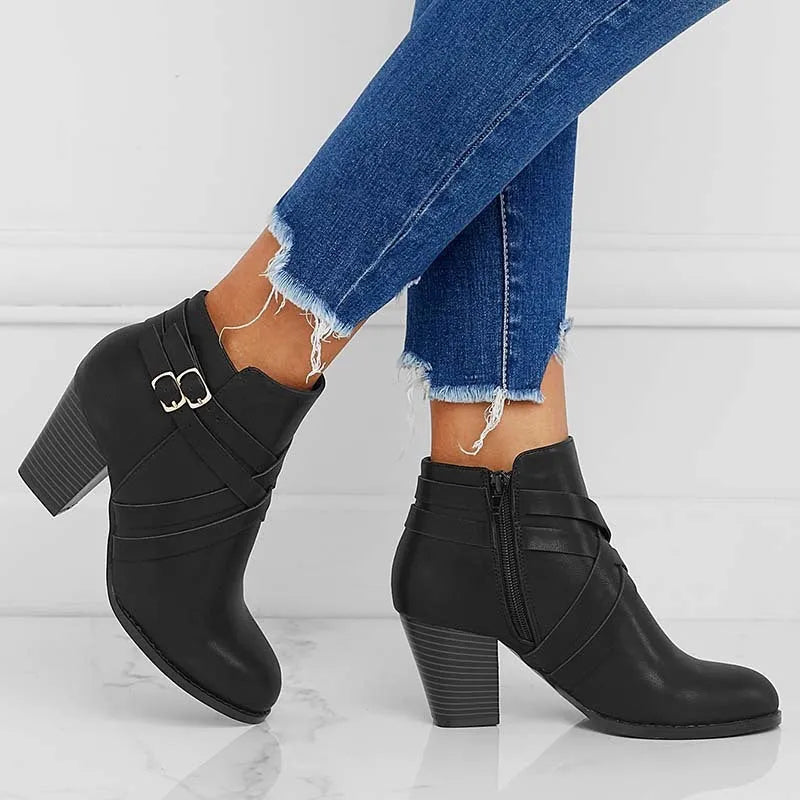 Women's short ankle boot with 7cm heel, side zipper, and belt buckle detail in grey.