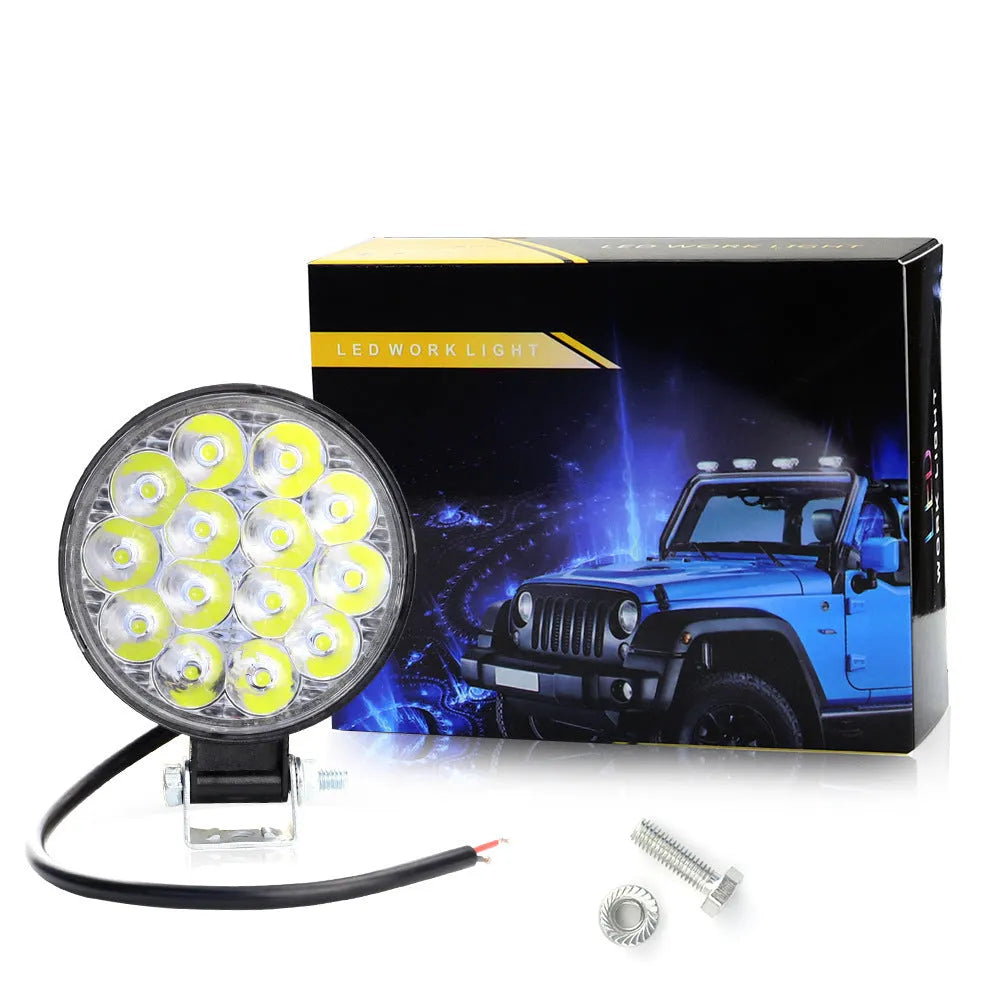 White aluminium LED work light with a round design, suitable for mounting on a vehicle.