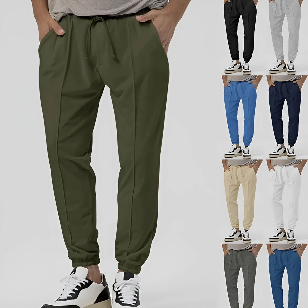 Man wearing grey loose tapered track sweatpants with a casual top