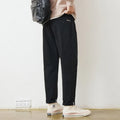 Men's loose wide-leg casual pants in dark khaki with zipper fly and mid-rise waist on a plain background