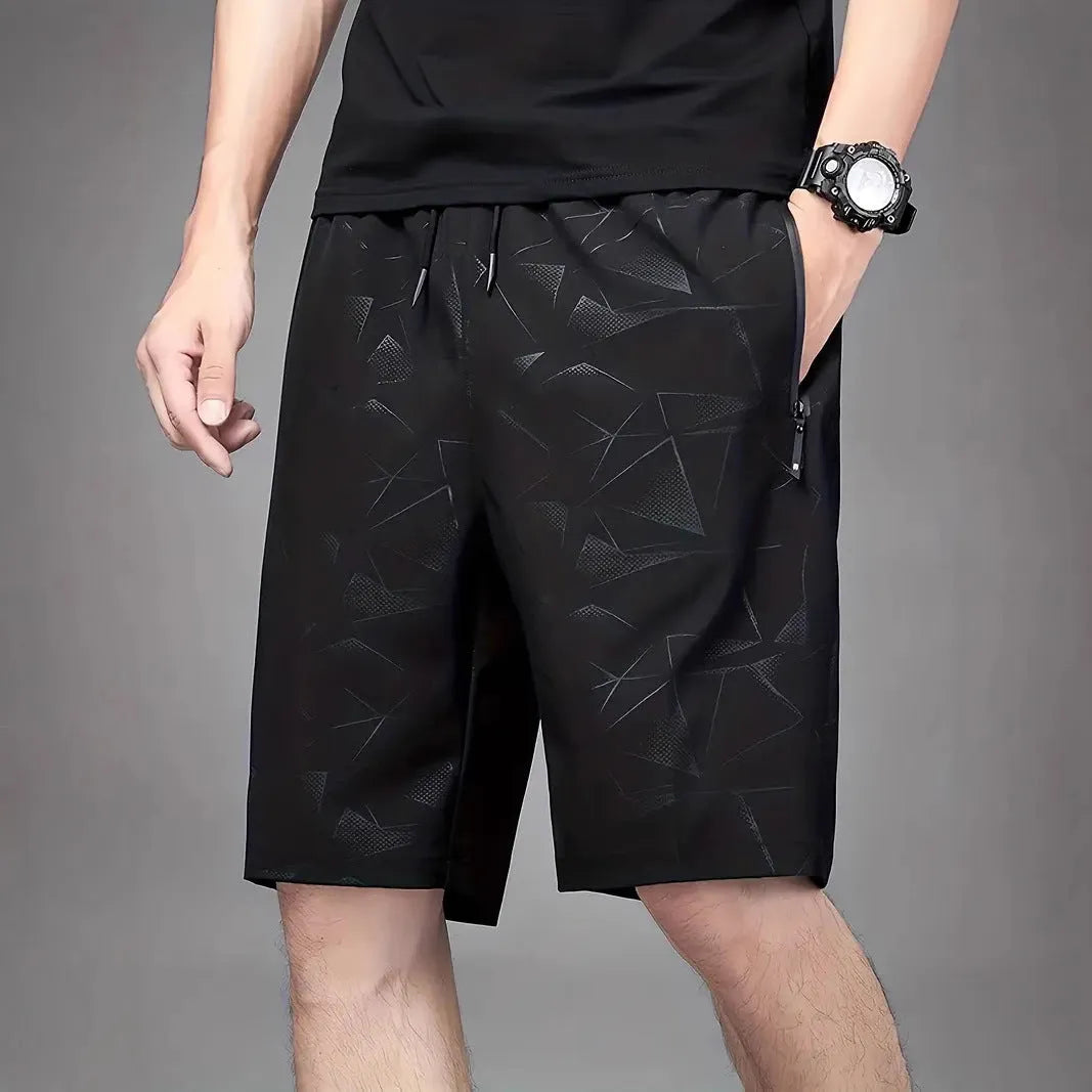 Man wearing loose fit grey polyester sports shorts with elastic waistband.