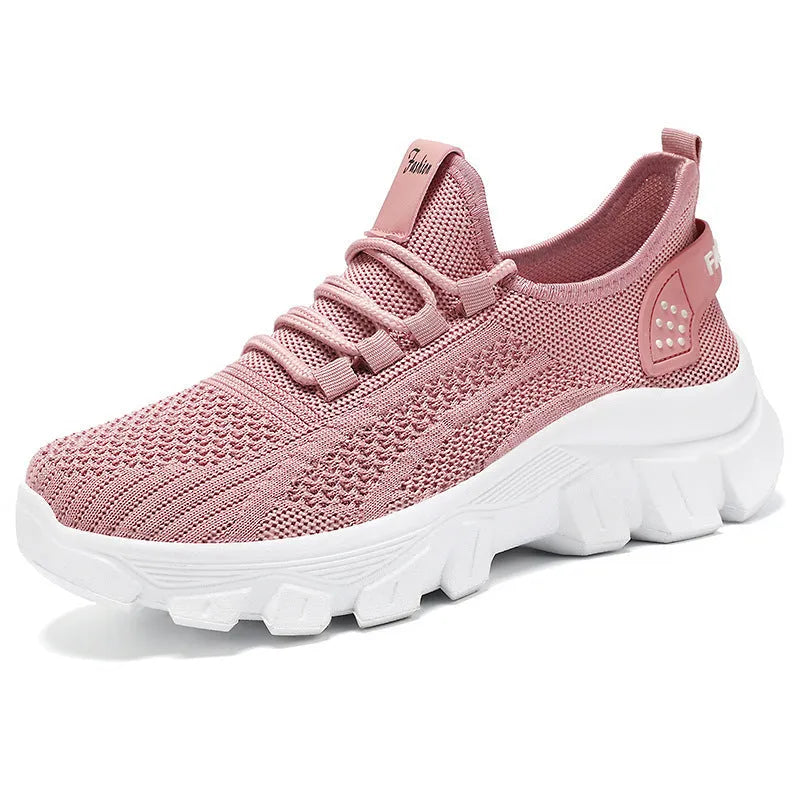 Women's white Flyknit lace-up sneakers with a thick PVC sole and round toe on a neutral background