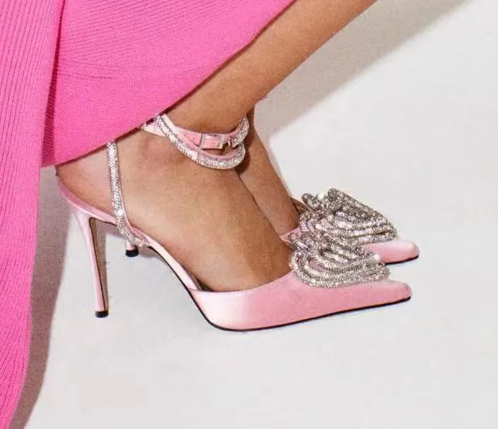Women's pointed-toe satin sandal with heart rhinestone and cross-belt strap in black, pink, or white.