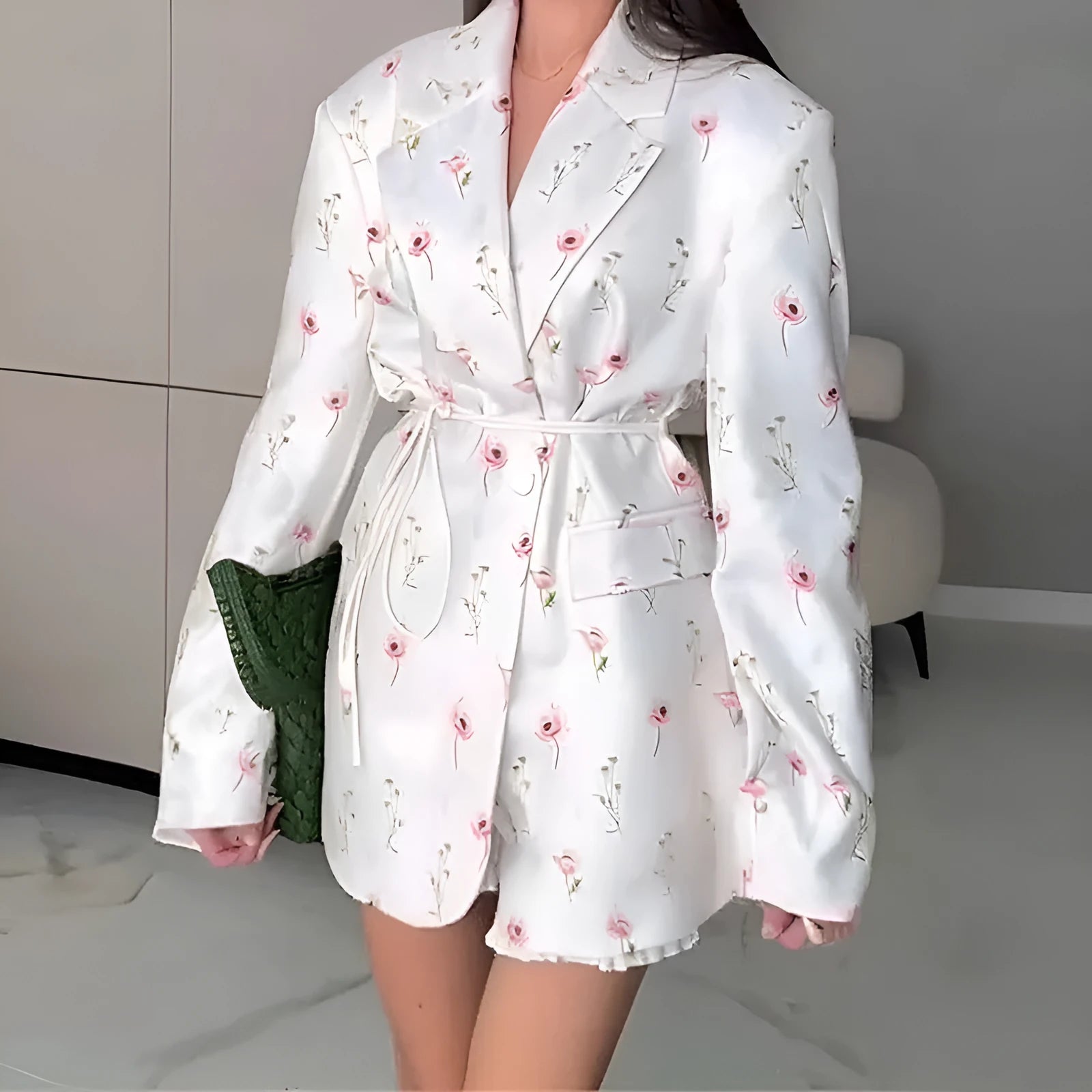 Women's floral print suit jacket with lace-up waist closure on a hanger.