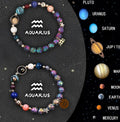 Two natural stone beaded bracelets showing zodiac sign designs on a flat surface.