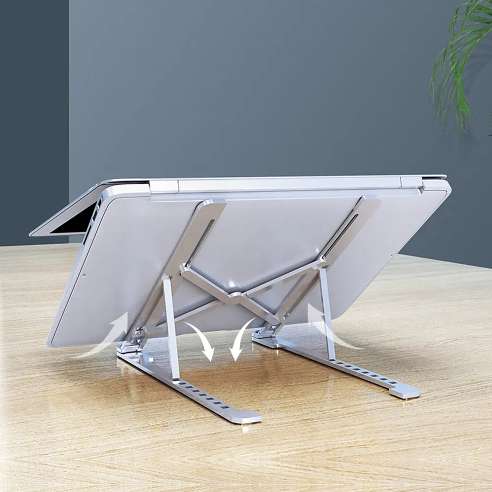 Portable aluminium laptop stand folded flat next to an open laptop showing its adjustable height.