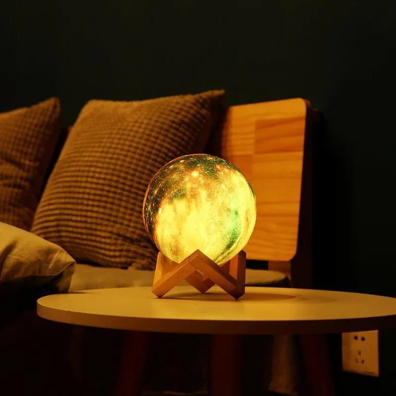 3D-printed spherical moon night light with colour-changing LED glow on a dark surface.