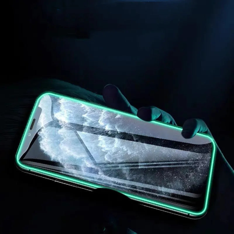 Luminous tempered glass screen protector for iPhone glowing softly in a dark setting.