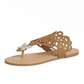 Women's black slip-on sandals with rhinestone decoration on the flip-toe, showing the flat heel and rubber sole.