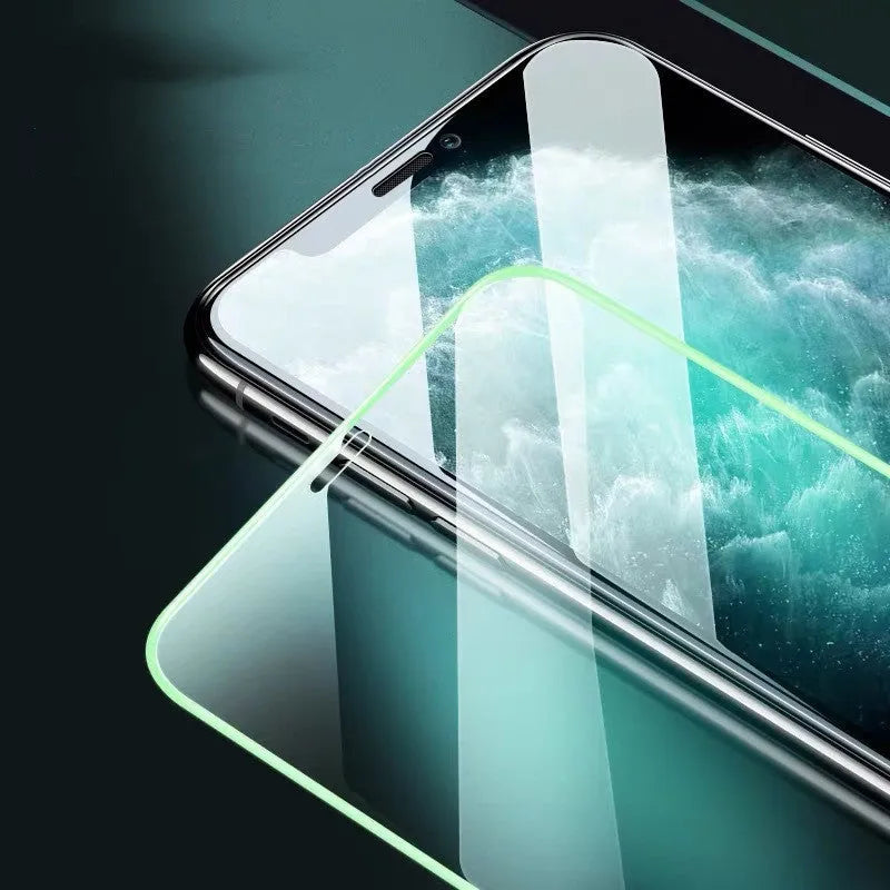 Luminous tempered glass screen protector for iPhone glowing softly in a dark setting.