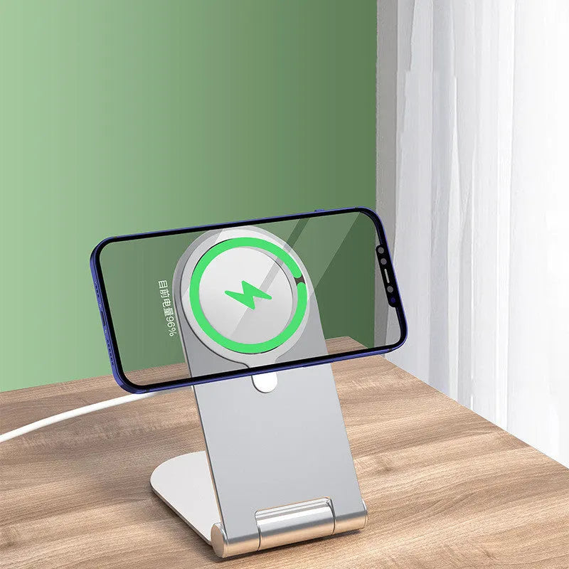 Silver vertical adjustable magnetic phone bracket on a desk, holding an iPhone 12.
