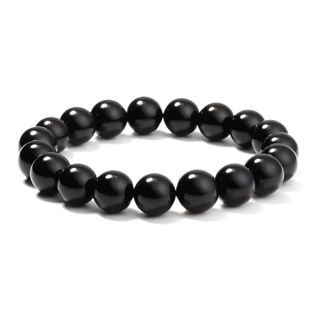 Close-up of a women's black onyx agate bracelet with 8mm geometric beads on a black elastic cord.