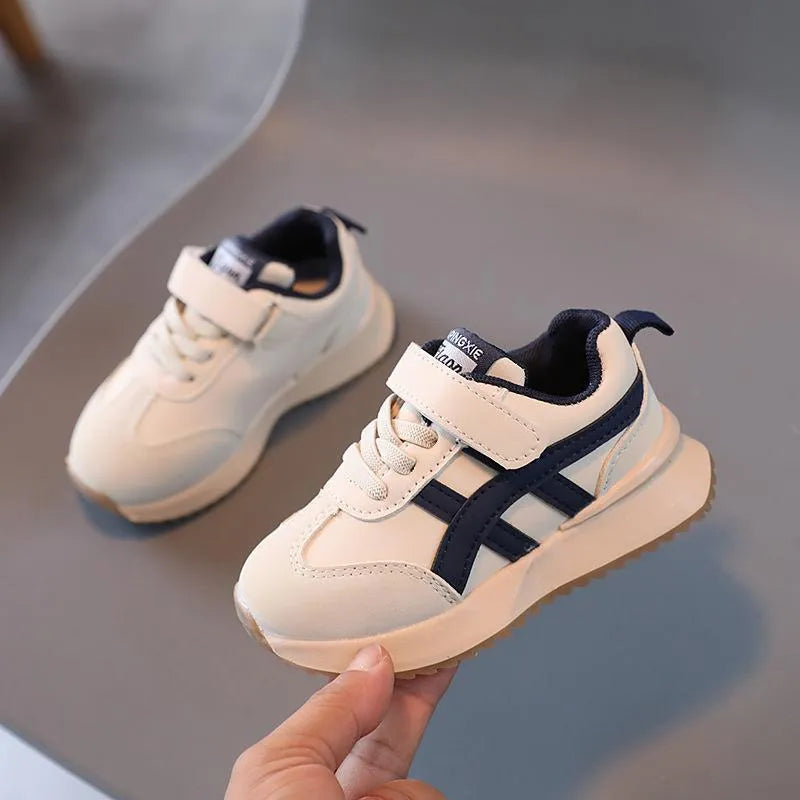 Children's white synthetic leather sneaker with Velcro strap on a rubber sole.
