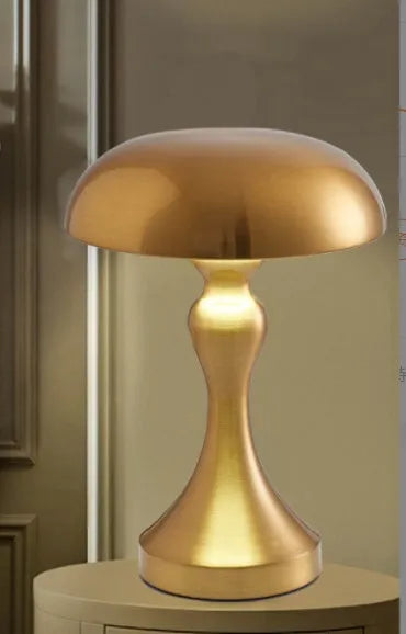 Metallic bronze USB rechargeable LED desk lamp with touch control on a wooden desk