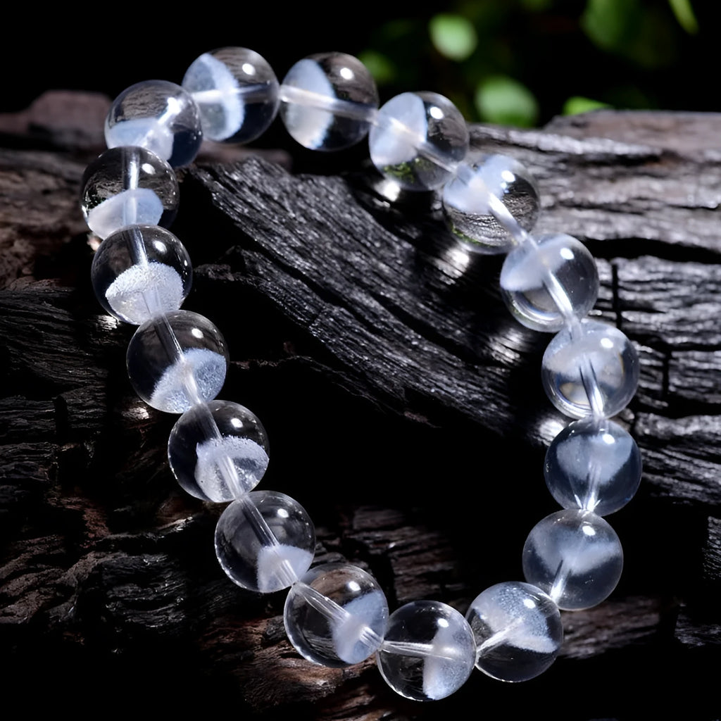 Women's white crystal ghost pyramid bracelet with ruyi charm on a wrist, showing bead detail.