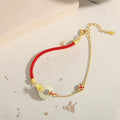 Gold electroplated 925 sterling silver bracelet with red rope and peace buckle featuring koi fish design