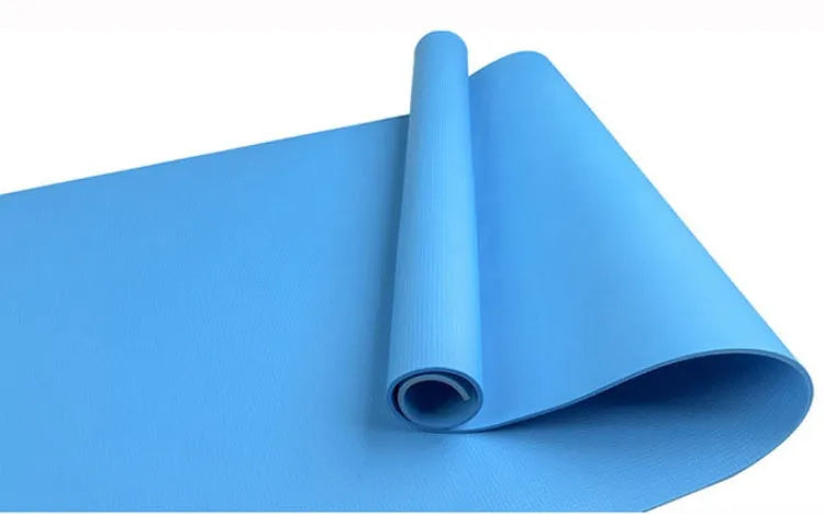 EVA foam yoga mat in blue, showing textured anti-slip surface, with a black OPP storage bag beside it.