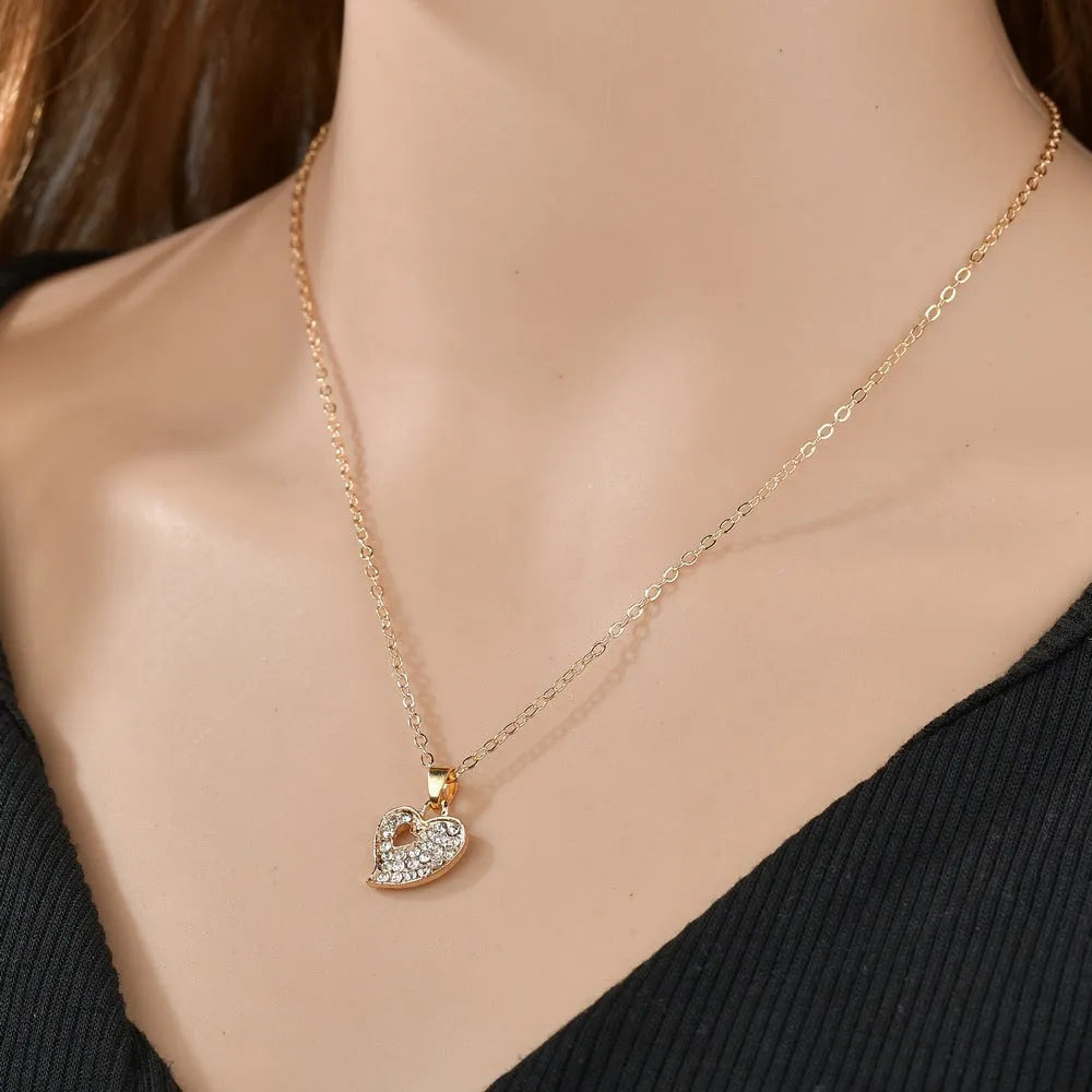 Gold-plated alloy women's jewellery set with earrings, necklace, and bracelet featuring love, water drop, and bell pendants.