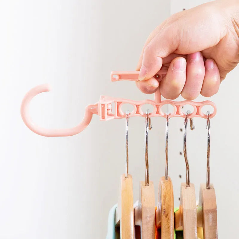 Magic revolving wardrobe hanger with five holes and handle in blue, green, or pink for clothes organisation