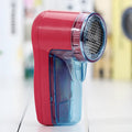 Portable electric clothing lint remover device on a sweater.