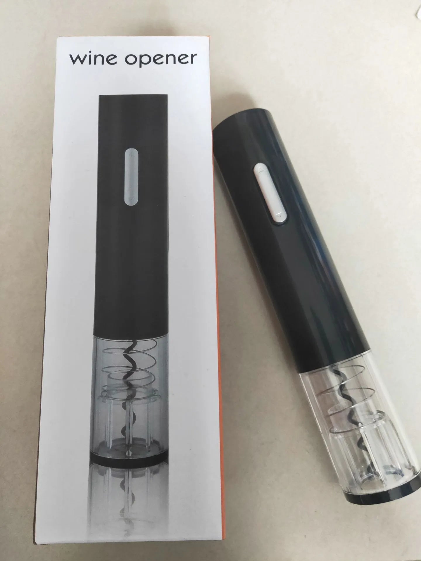 Black automatic electric wine opener with foil cutter and transparent window on white background